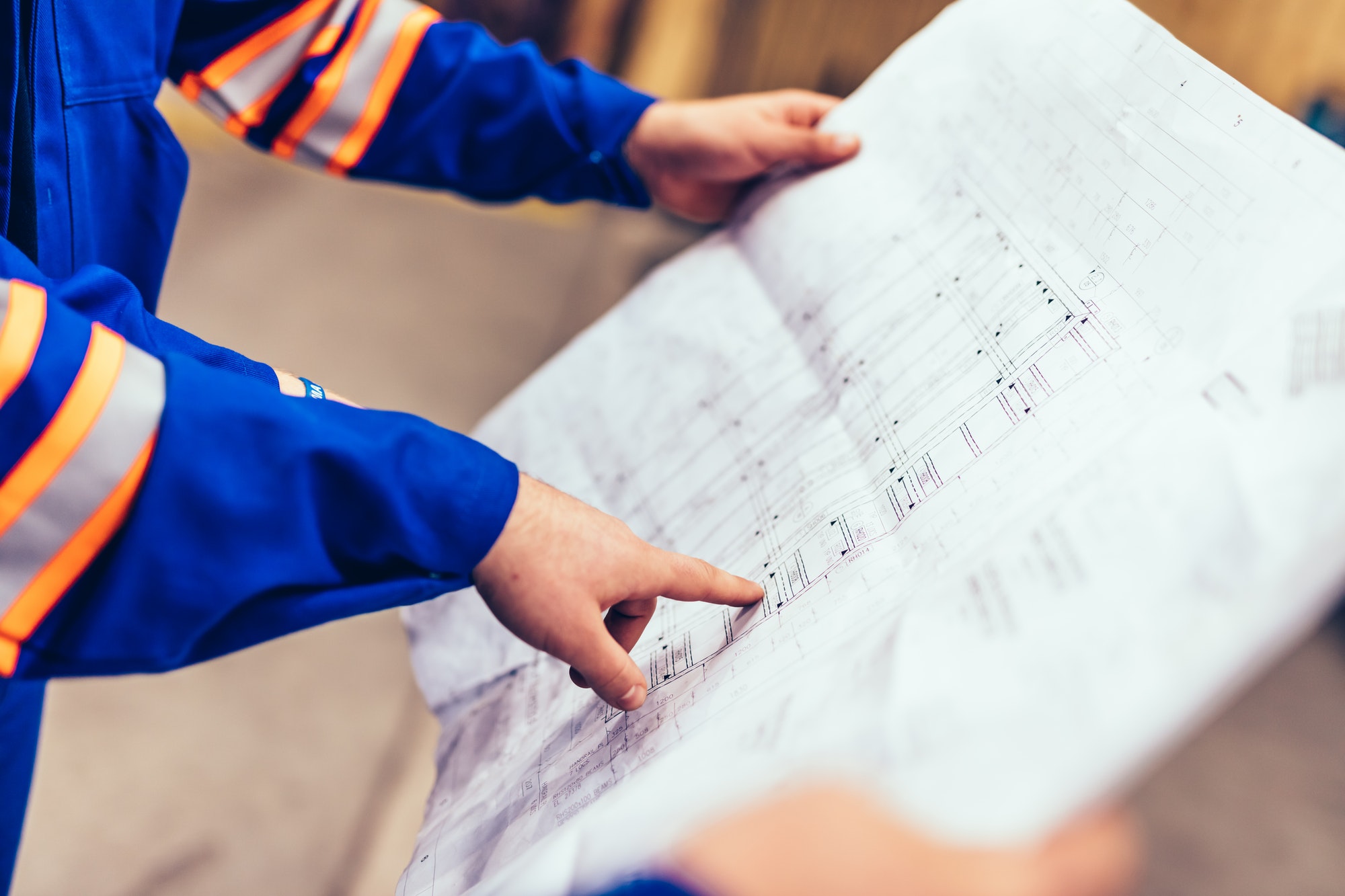 Engineers showing construction plans in a factory.